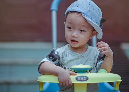 Boy Sitting on Yellow and Blue Trike thumbnail