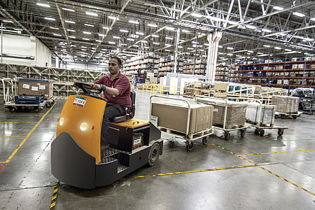 man driving cart with boxes inside building thumbnail