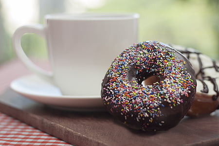 two chocolate daughnuts beside teacup thumbnail