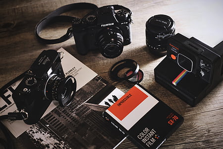 three black cameras and lens on table thumbnail