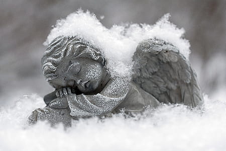 sleeping angel figurine covered by snow thumbnail
