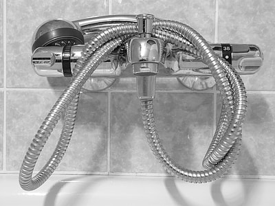 gray stainless steel faucet with shower head on gray wall thumbnail