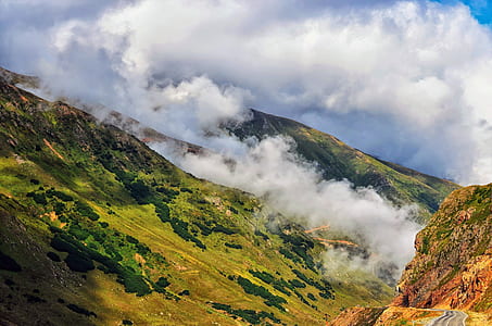 green mountain with white smoke at daytime thumbnail