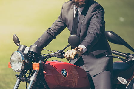 man in black formal suit riding red BMW standard motorcycle thumbnail