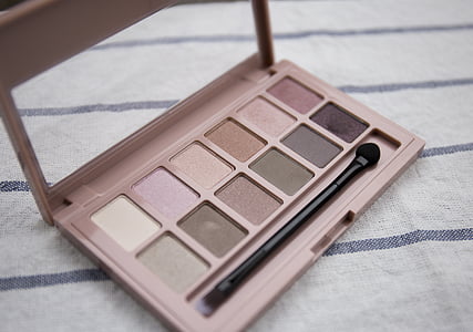 brown makeup palette with black makeup brush on white and gray surface thumbnail