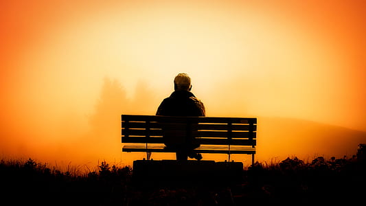 man sitting on a bench taken on sunset thumbnail