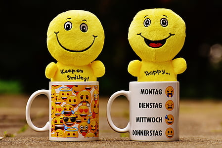 two yellow emoji plush toys on white ceramic mugs thumbnail