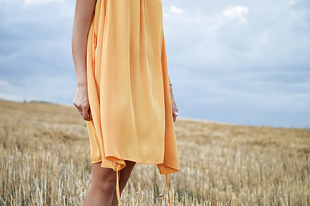 woman wearing yellow dress standing between field thumbnail