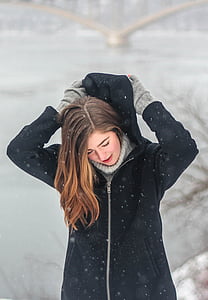 woman wearing black coat standing on snow during daytime thumbnail