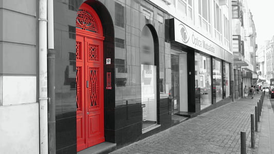 closed red wooden door near concrete road thumbnail