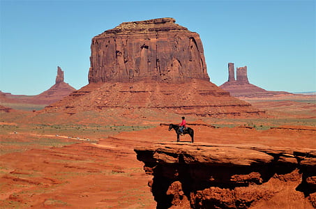 person riding horse on mountain cliff thumbnail