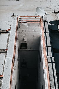 gray DirecTV parabolic antenna on top of white concrete building thumbnail