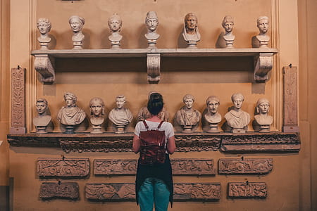 woman standing in front of assorted headbusts thumbnail