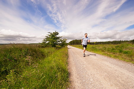 man running on dirt road during daytime thumbnail