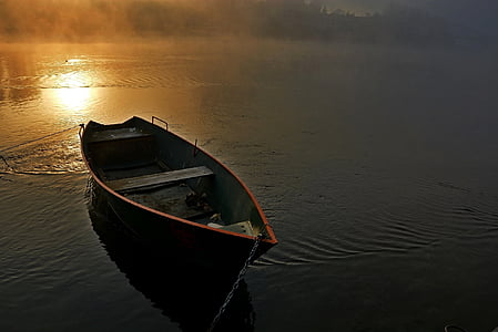 brown wooden canoe at water during daytime thumbnail