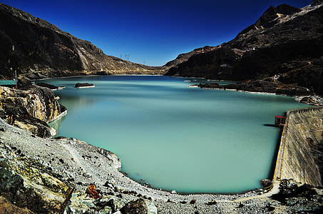 lake surrounded by mountains under blue sky thumbnail