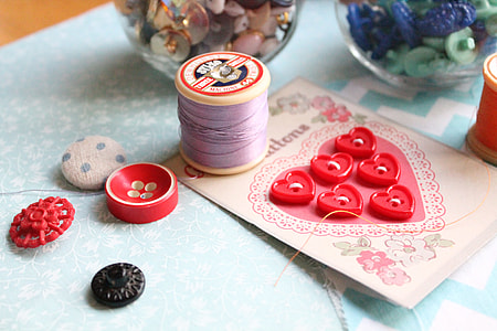 photo of purple sewing thread beside red cloth button thumbnail