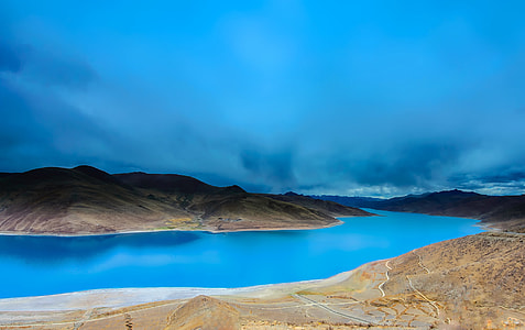 body of water near mountain at daytime thumbnail