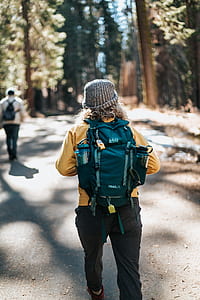 tilt-shift photography of woman carring backpack thumbnail