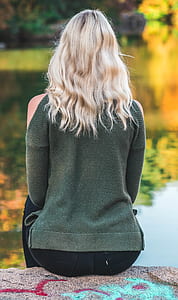 woman sitting in front of body of water thumbnail