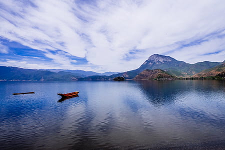 boat on body of water with mountains thumbnail