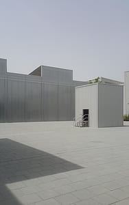 square white metal shed surrounded by white buildings at daytime thumbnail