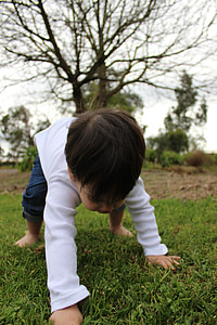 selective focus photography of boy crawling on ground thumbnail