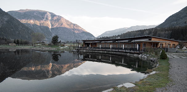 body of water near brown wooden house thumbnail