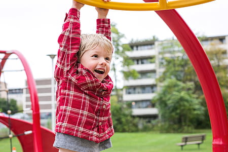 Boy Hanging At Playground Photo thumbnail