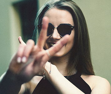 woman wearing black sunglasses showing hand gesture thumbnail