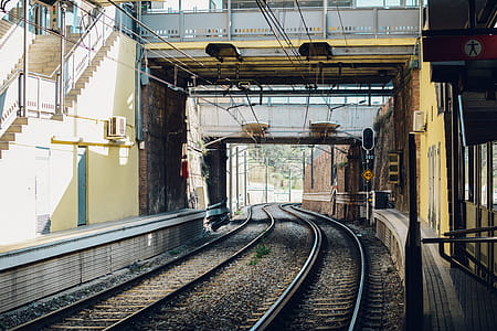 Gray Train Rail Under Yellow and Gray Building thumbnail