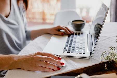 A woman works at a desk with a laptop and a cup of coffee thumbnail