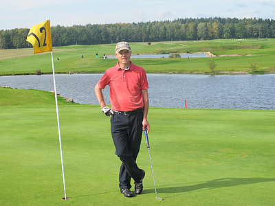 man standing on green grass holding golf putter thumbnail
