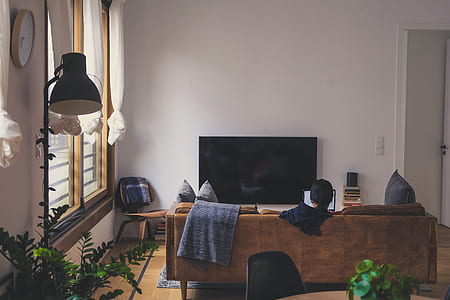 black flat screen TV on brown wooden sideboard thumbnail