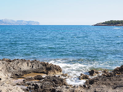 body of water near rock formation thumbnail