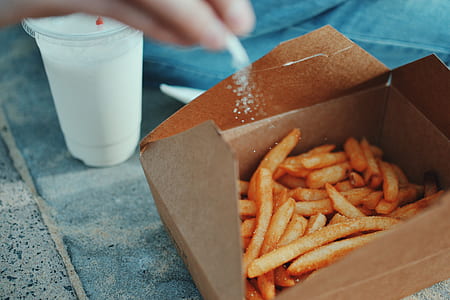 person putting salt on french fries thumbnail