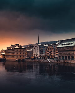 buildings beside body of water at golden hour thumbnail