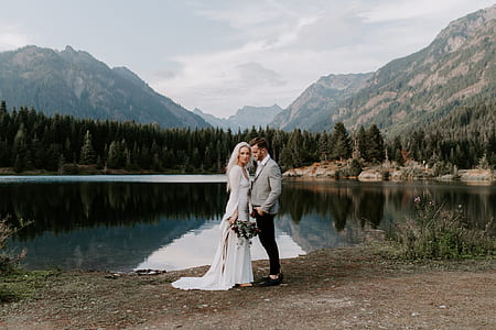wedding couple standing in front of mountains thumbnail