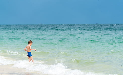 boy on seashore standing during daytime thumbnail