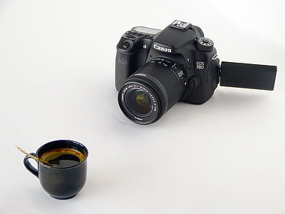 black ceramic coffee cup on white surface near black Canon EOS DSLR camera thumbnail