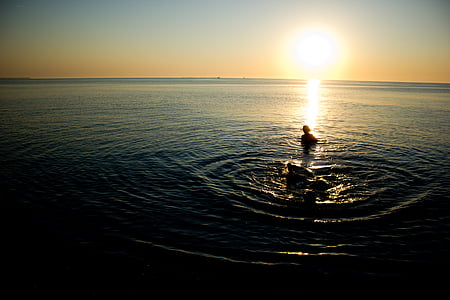 body of water under yellow sky thumbnail