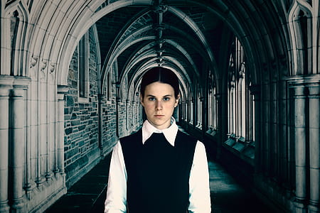 woman wearing black sweater jacket and white long-sleeved top on hallway thumbnail
