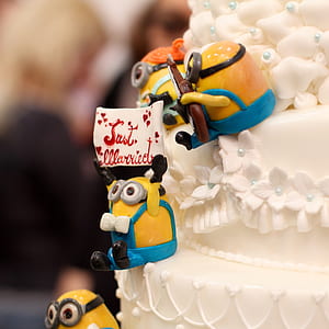 Minions holding Just Married sign sitting on white wedding cake thumbnail