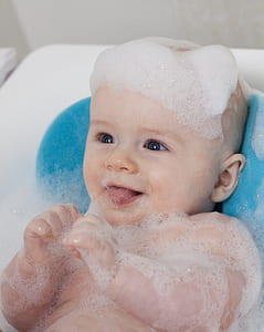closeup photography of bathing baby on plastic bather thumbnail