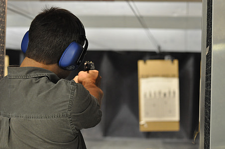 man holding gun inside shooting room thumbnail