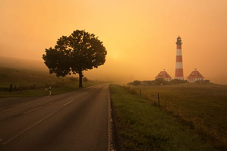 white and red lighthouse beside two houses thumbnail