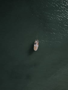 white and beige boat sailing on body of water thumbnail