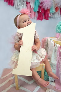 girl holding letter 1 standee while sitting on stool thumbnail
