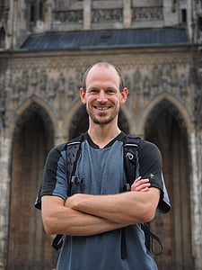 smiling man standing near brown concrete building thumbnail
