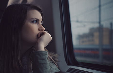 woman wearing gray jacket looking on window thumbnail